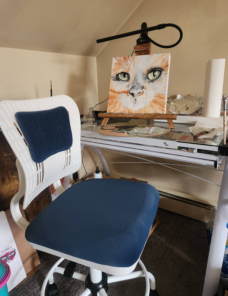 lauren kate's art space - the desk where she paints. An in progress cat painting sits on top
